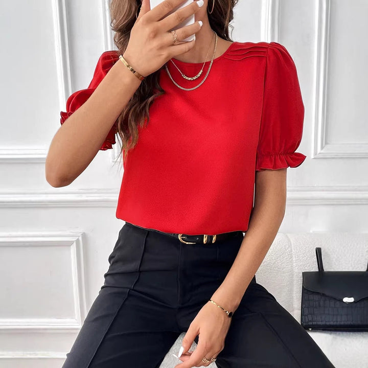 Detailaufnahme der Bluse: Dezente Schulterfalten und Volants an den Puffärmeln. Feminines Design.