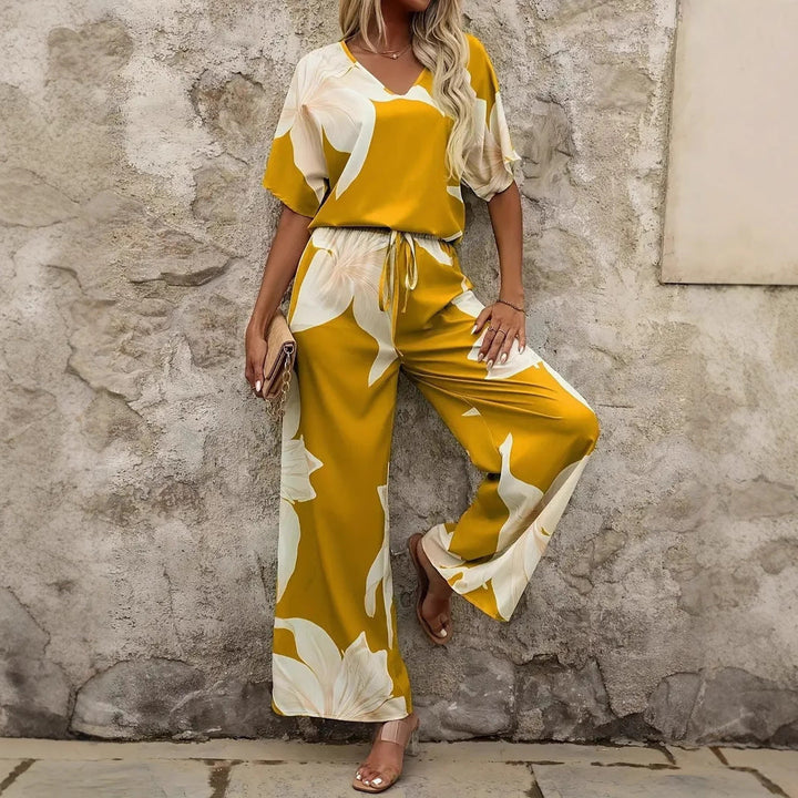 Elegante Frau trägt blumigen Sommer Hosenanzug, ideal für stilvolle Urlaubstage und Freizeit.