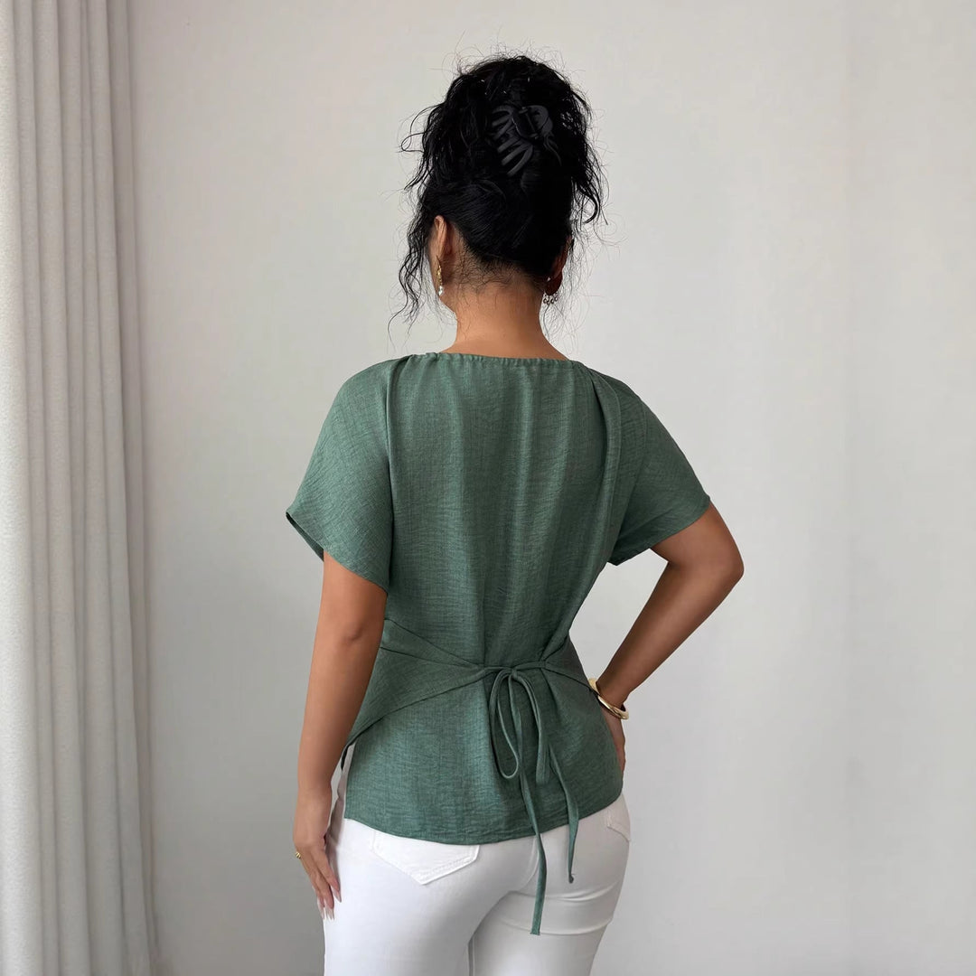 Tailliertes Kurzarm-Top für Damen mit vorteilhafter Drapierung. Das Perlen-Detail & die Schlüsselöffnung sind elegant.