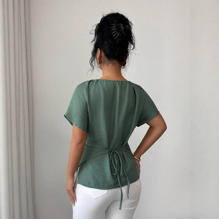 Tailliertes Kurzarm-Top für Damen mit vorteilhafter Drapierung. Das Perlen-Detail & die Schlüsselöffnung sind elegant.