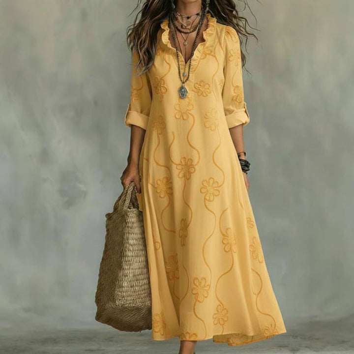 Damen Maxikleid mit V-Ausschnitt & floraler Stickerei, getragen von einem Model. Zeigt den stilvollen Fall.