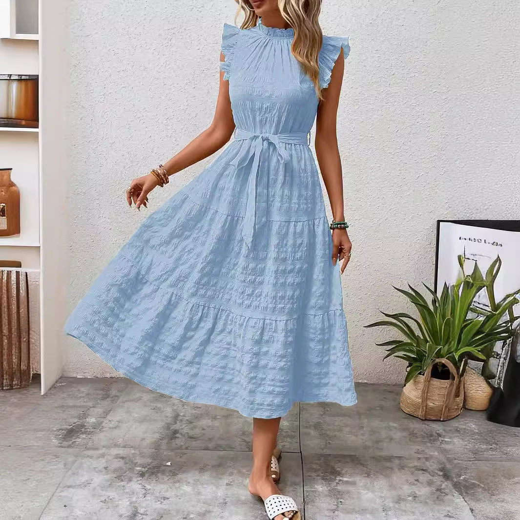 Model trägt elegantes Damen Midikleid mit Stehkragen, Rüschenärmeln und Taillengürtel. Luftiges Sommerkleid.