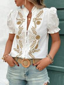 Modell trägt bestickte Damen-Kurzarmbluse mit Puffärmeln und Stehkragen. Eleganter Boho-Stil für Sommer.