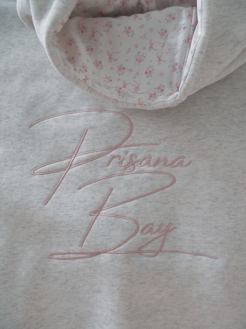 Damen Hoodie Elodie, weiß, mit Schleifenmotiv. Gemütlicher Kapuzenpullover für Freizeit & Alltag.
