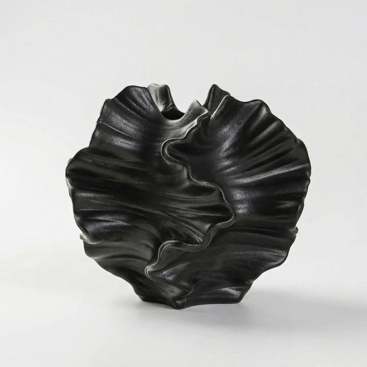 Zeitlose Blumenvase mit wellenförmigem Design, ideal für moderne Wohnzimmerdeko und Akzente in Schwarz.