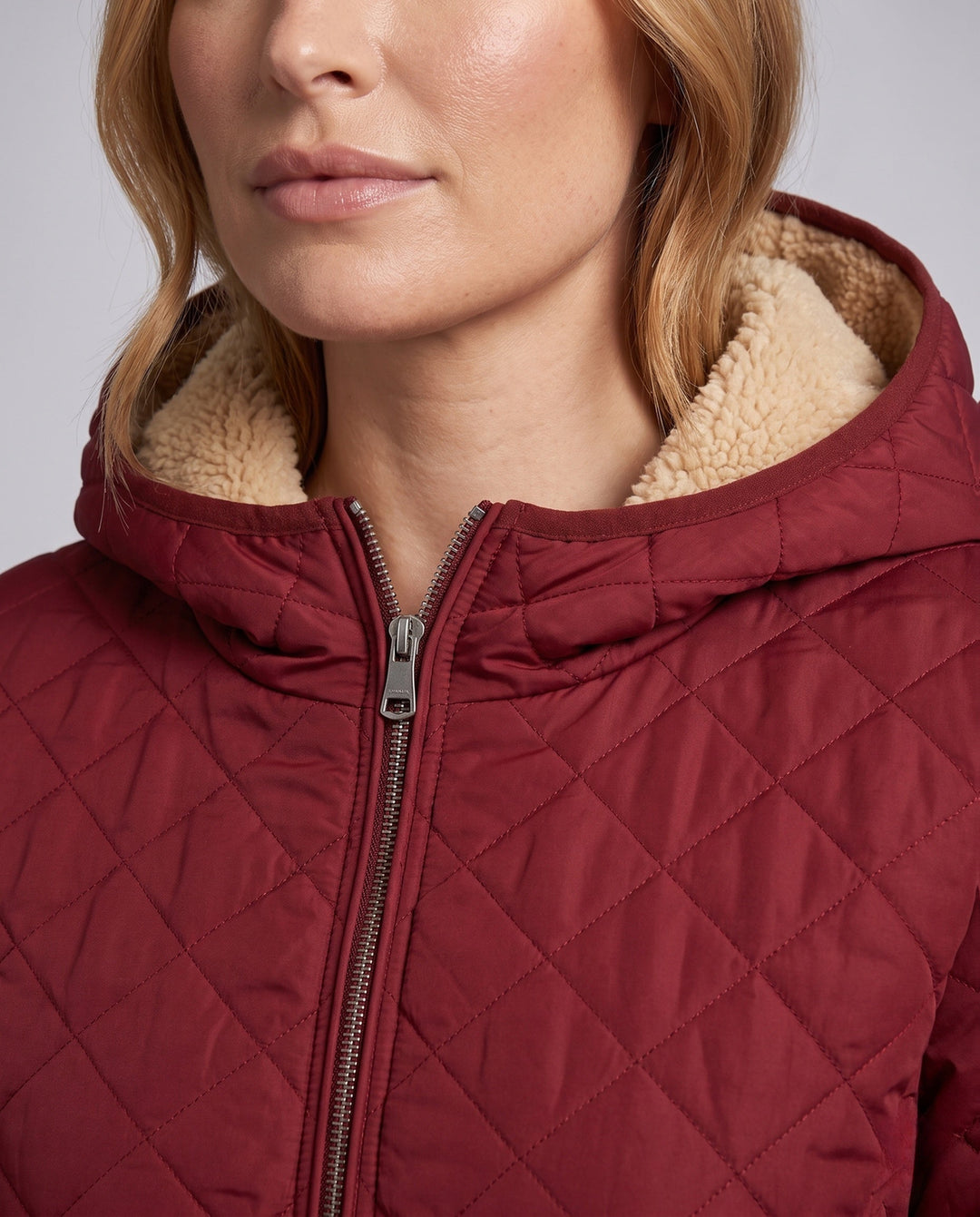 Frau trägt leichte Damen Steppjacke mit Kapuze, perfekt für Outdoor-Aktivitäten im Winter.