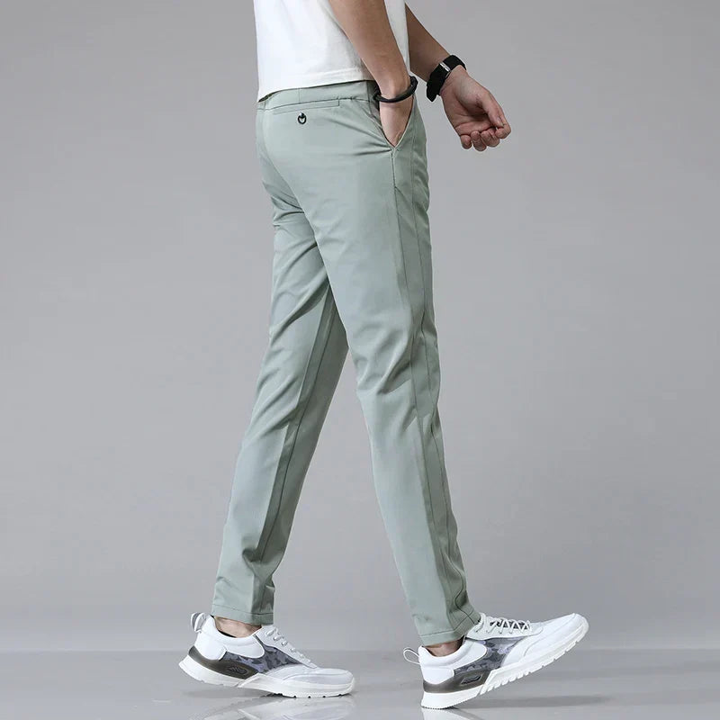 Mann trägt elegante Herren Stretchhose im Slim Fit, präsentiert den bequemen Sitz und den modernen Style.