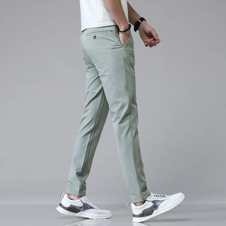 Mann trägt elegante Herren Stretchhose im Slim Fit, präsentiert den bequemen Sitz und den modernen Style.