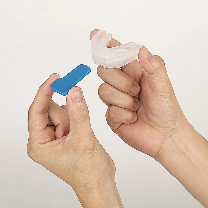 Hand hält flexiblen Silikon-Mundschutz als Schlafhilfe gegen Schnarchen und Zähneknirschen.