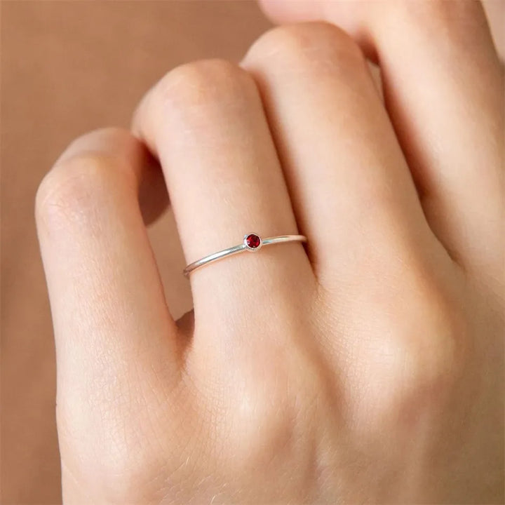 Damen Geburtssteinring am Finger getragen, personalisierter Schmuck, elegantes Accessoire für jeden Tag.