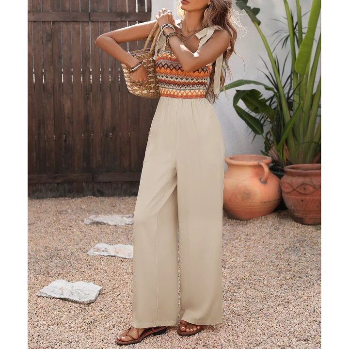 Detailaufnahme: Fließender Stoff des aprikosenfarbenen Damen Jumpsuits mit weitem Bein und feinen Spaghettiträgern.
