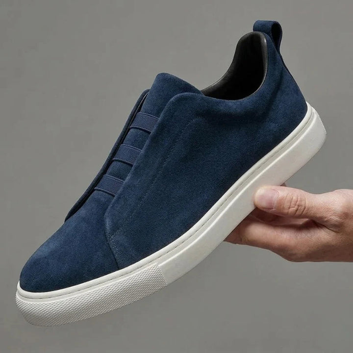 Mann trägt schwarze Herren Slip-on Sneaker. Perfekt für lässigen Stil & mühelosen Komfort.