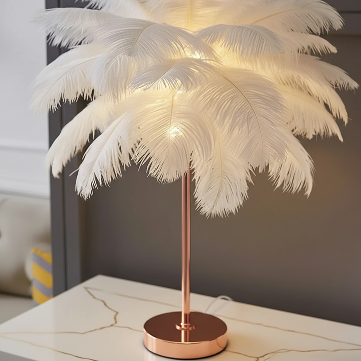 Moderne Schlafzimmerlampe: Feder-Tischleuchte mit glänzendem Roségold-Fuß, spendet warmes, gemütliches Licht.