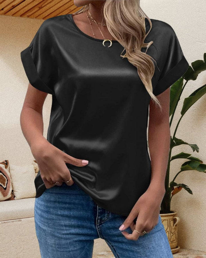 Detailansicht einer glänzenden Damen Kurzarm-Bluse mit Rundhalsausschnitt, ein stilvolles und bequemes Top.