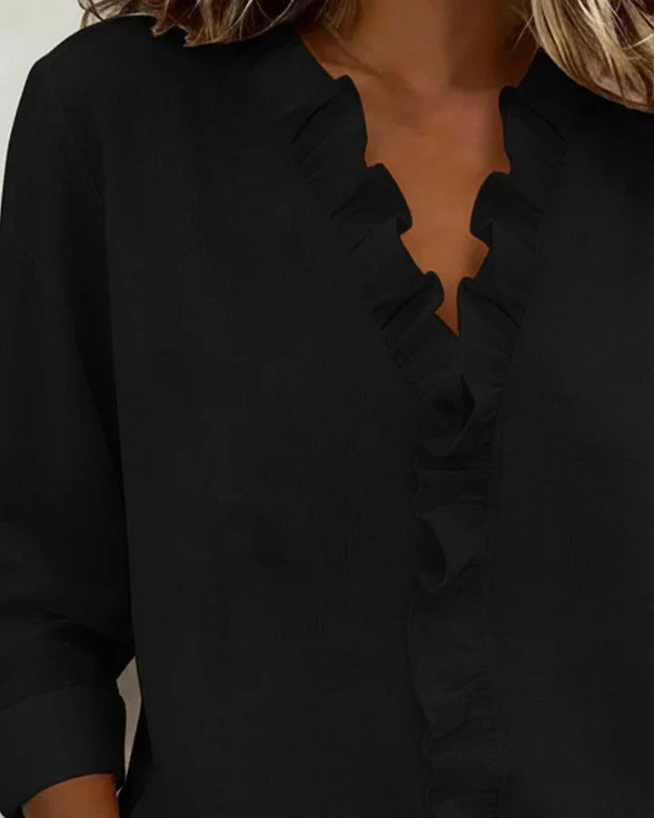 Damen Langarmbluse mit V-Ausschnitt und Rüschen, elegant getragen von einem Model, ideal für Herbstmode.