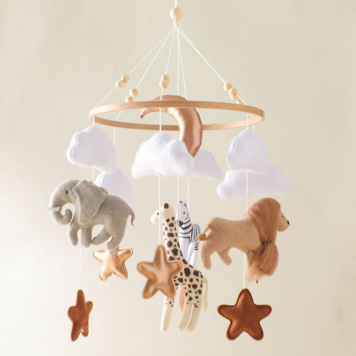 Handgefertigtes Baby Mobile mit farbenfrohen Filz-Safaritieren wie Löwe, Elefant und Giraffe, ideal fürs Babyzimmer.