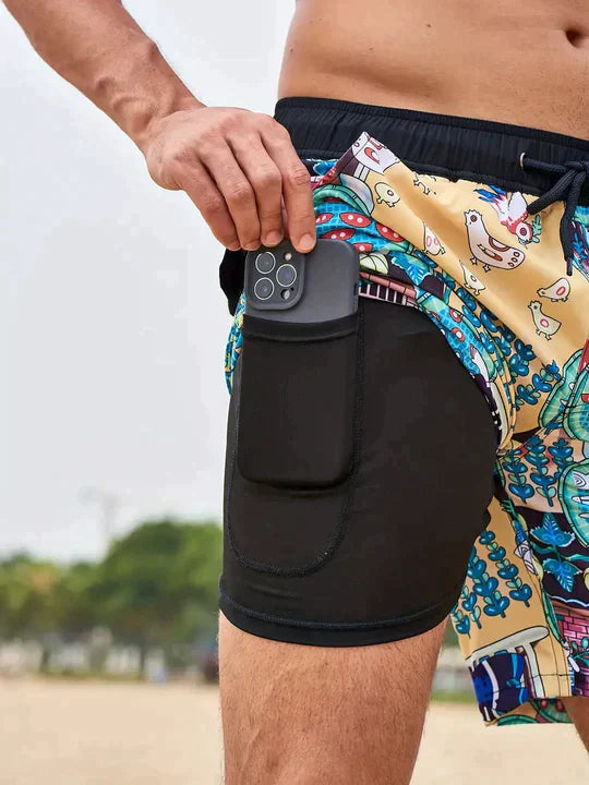 Mann am Strand in moderner Badehose mit Handytasche; stilvolle Sommer Bademode für Herren.