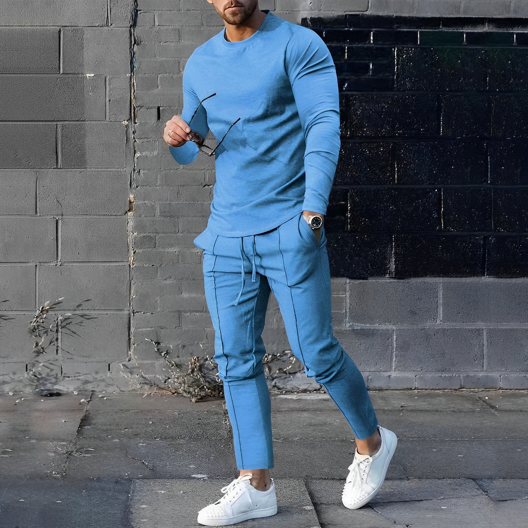 Mann trägt stilvollen Herren Loungewear Zweiteiler: Pullover und Jogginghose für entspannte Stunden.