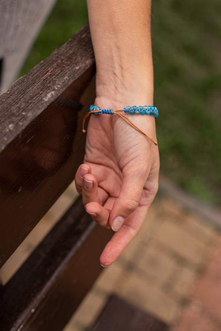 Nahaufnahme: Handgefertigtes Damenarmband aus blauem Opal. Funkelnder Blauer Quarz Edelsteinschmuck, spirituell.