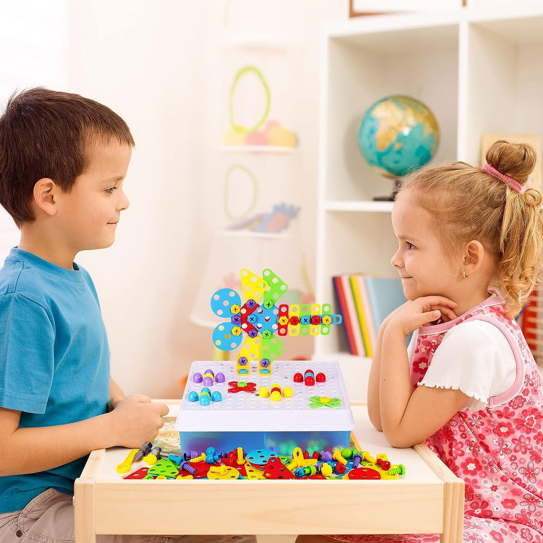 Ein Kind bohrt spielerisch mit der Spielzeugbohrmaschine in ein Bauteil des Konstruktionsspielzeugs.