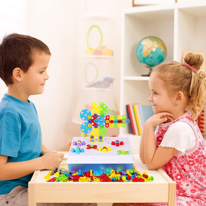 Ein Kind bohrt spielerisch mit der Spielzeugbohrmaschine in ein Bauteil des Konstruktionsspielzeugs.