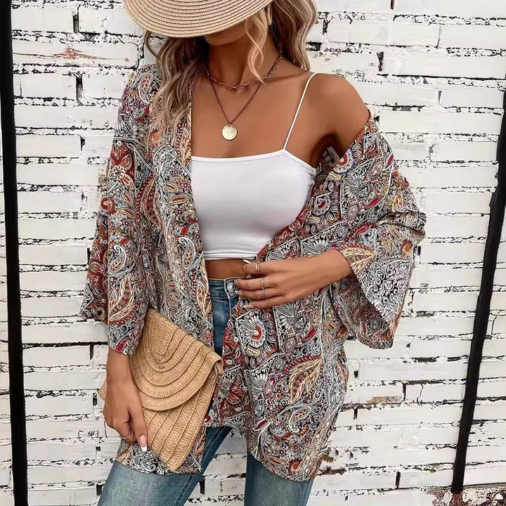 Moderne Damenbluse im eleganten Kimono-Stil mit lebhaftem Ethnomuster. Eine stilvolle Rundhalsbluse für den Alltag.