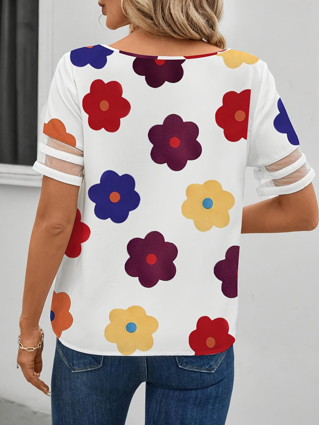Damen Kurzarm-Bluse mit modernem asymmetrischem Ausschnitt und lebhaftem Blumenmuster.