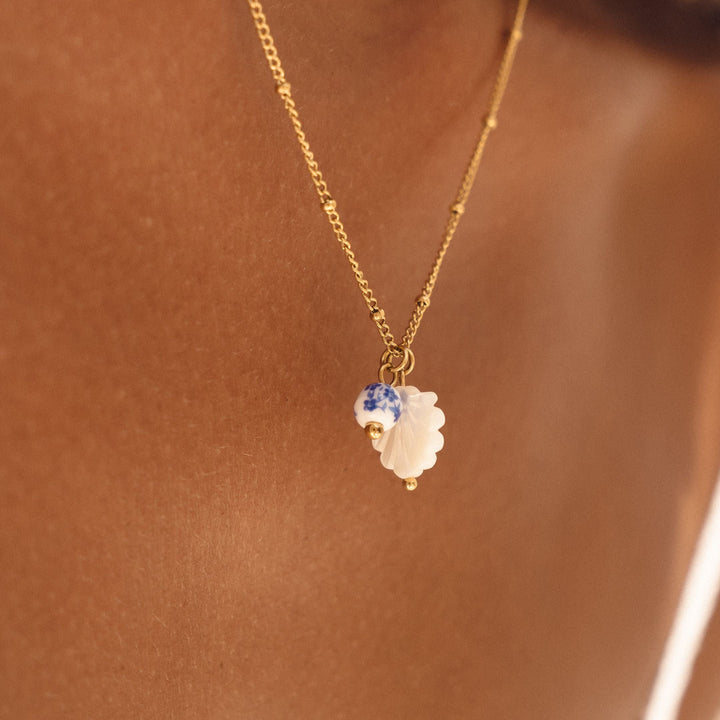 Goldene Damenhalskette aus Edelstahl mit Perlmutt & weißer Keramikperle. Hypoallergener, wasserfester Schmuck.