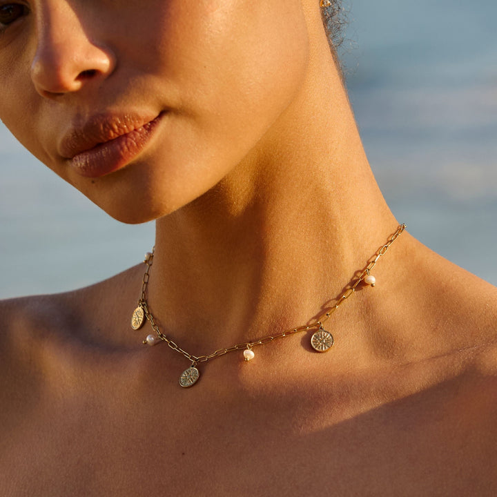 Edler Damen Choker mit glänzenden Süßwasserperlen und goldenem Sonnen-Anhänger. Perfekter Sommerschmuck.