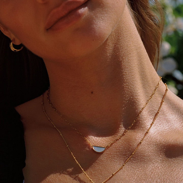 Modische goldene Choker Halskette mit ovalem Perlmutt Anhänger für Damen.