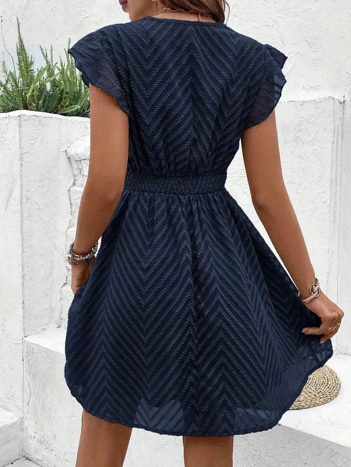 Detailaufnahme des V-Ausschnitts und der feinen Spitze am Damen Sommerkleid. Ein elegantes Boho Kleid.