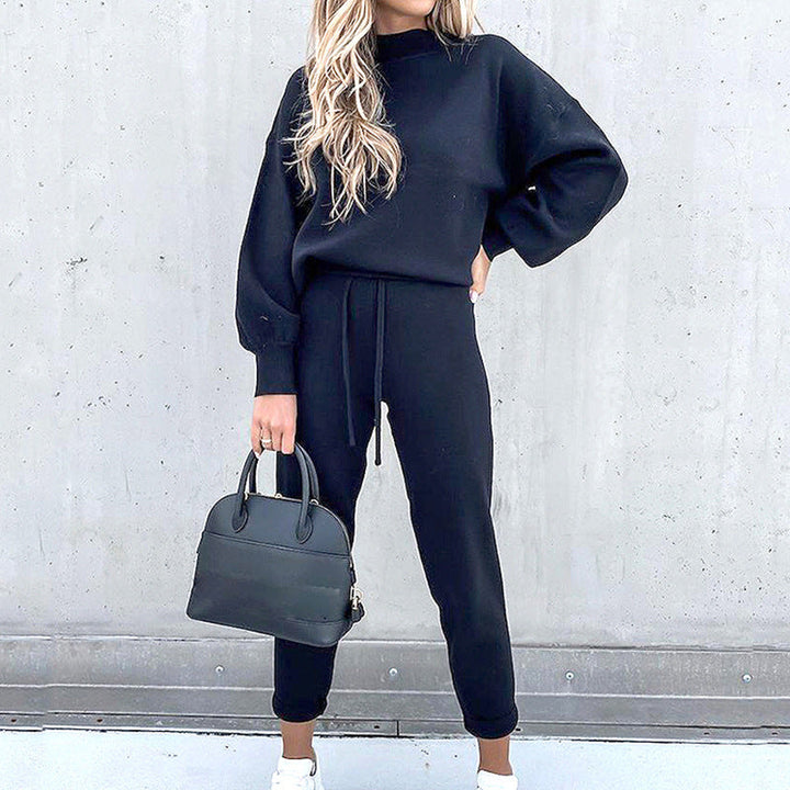 Model trägt den bequemen Damen Loungewear Zweiteiler mit Rollkragen-Pullover & Hose, entspannt im Raum.
