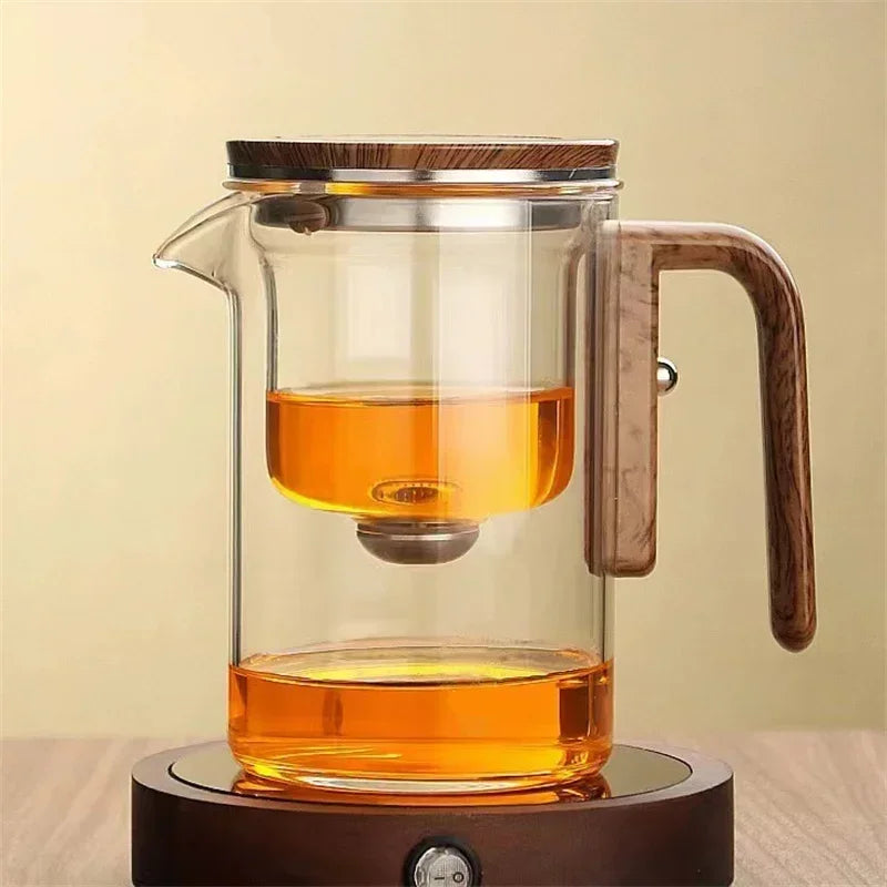 Transparente Glasteekanne mit modernem Design, feinem Filter und ergonomischem Holzgriff für aromatischen Teegenuss.