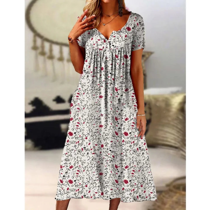 Model trägt elegantes A-Linien Damenkleid mit floralem Muster, V-Ausschnitt und kurzen Ärmeln.