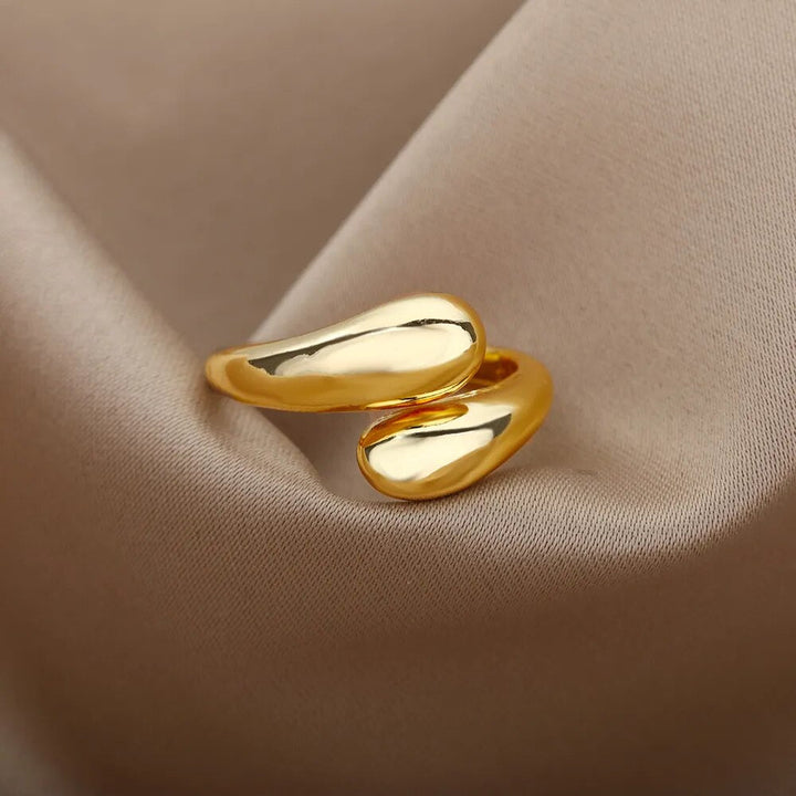 Moderner offener Ring für Damen mit zwei glänzenden goldenen Perlen. Ein stilvolles Schmuck-Accessoire in Gold.
