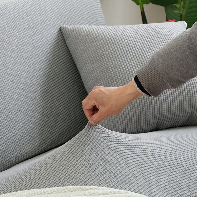 Trendige Stretchhülle in Koralle. Moderner Farbwechsel & effizienter Möbelschutz für Ihr Sofa.