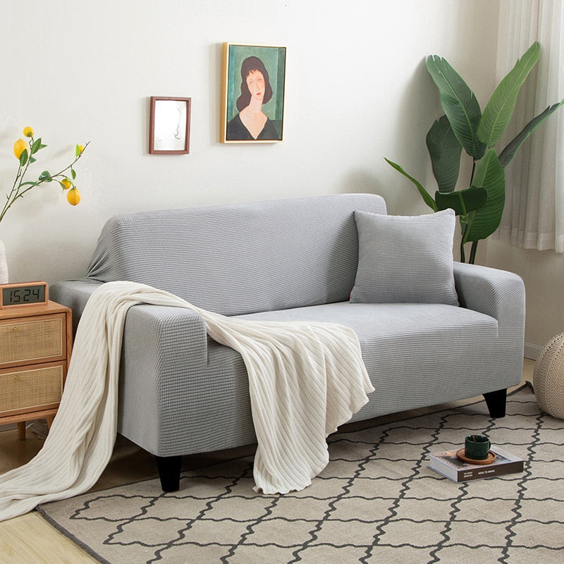 Pflegeleichte Schutzhülle in Taupe. Dehnbarer Couchbezug, ideal für Kinderzimmer, hygienisch.