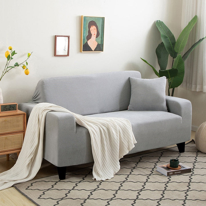 Pflegeleichte Schutzhülle in Taupe. Dehnbarer Couchbezug, ideal für Kinderzimmer, hygienisch.