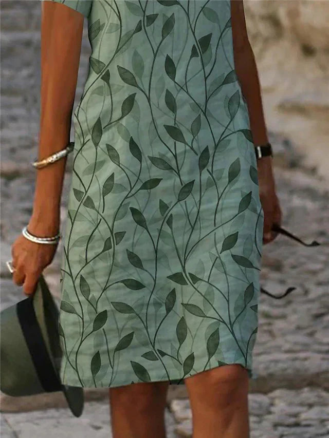 Grünes Damen-Midikleid mit ansprechendem Muster, V-Ausschnitt und kurzen Ärmeln. Perfekt als festliches Sommerkleid.