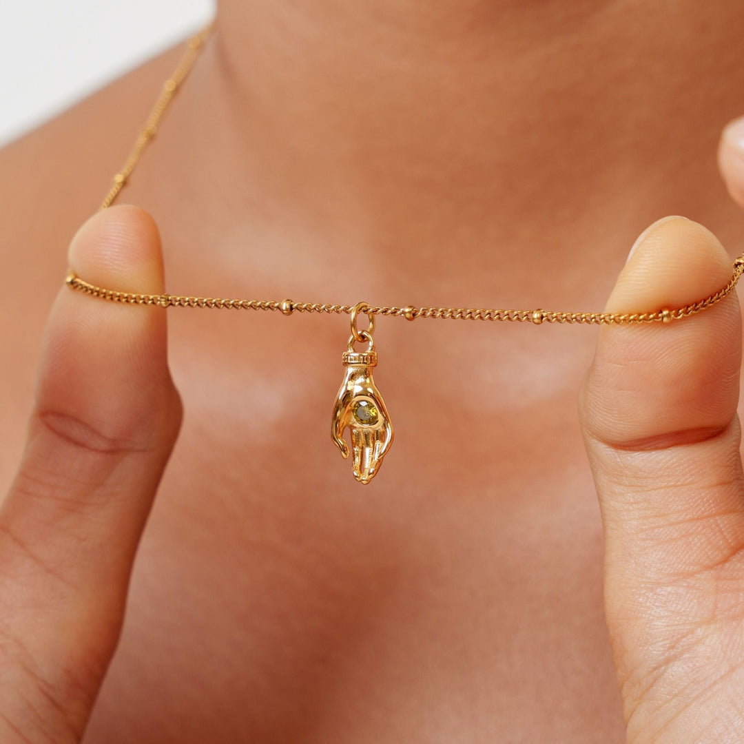 Feine Damenhalskette goldfarben mit Schutz Hand Anhänger und grünem Zirkon. Trendiger Schmuck aus Edelstahl.