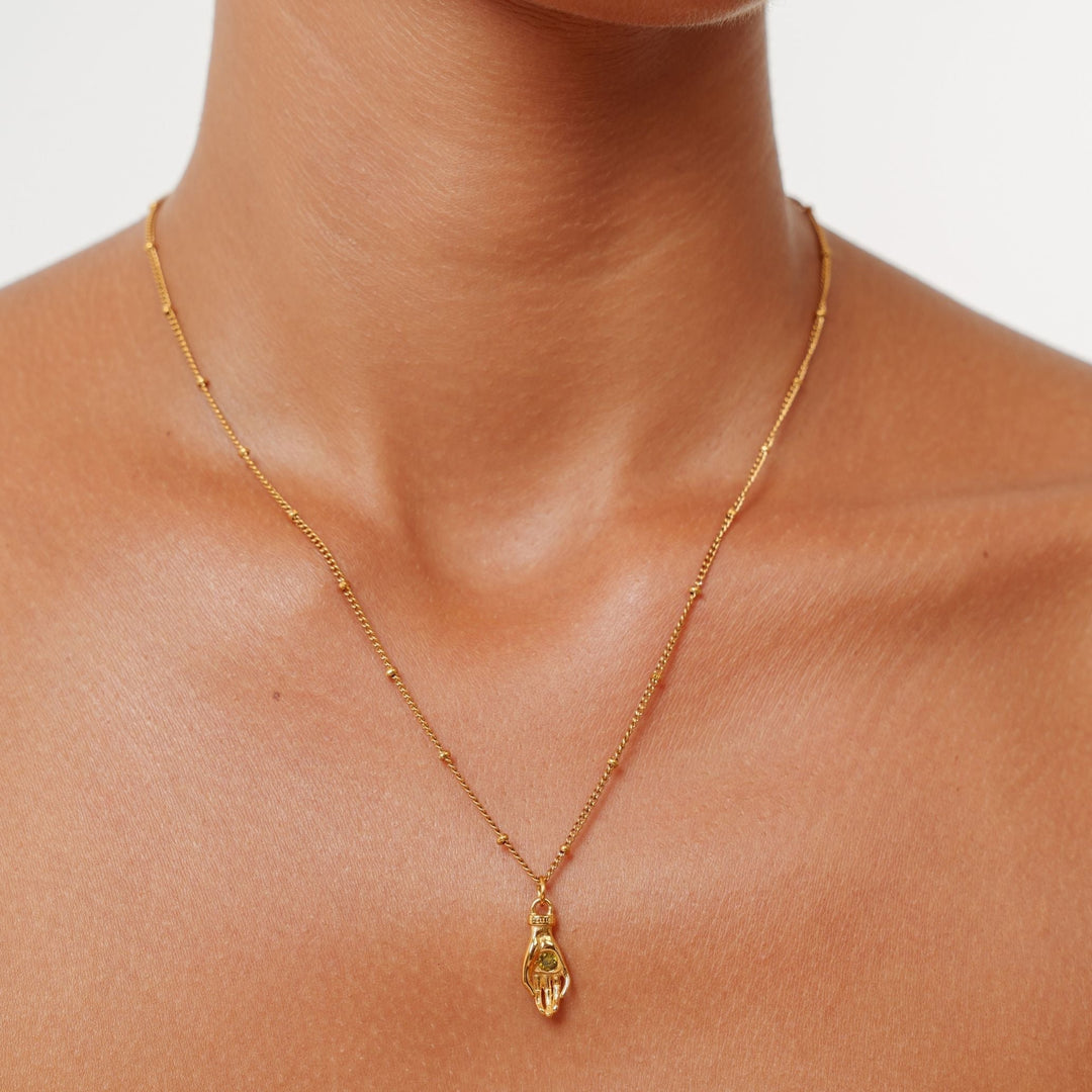 Robuste goldfarbene Damen Halskette aus PVD beschichtetem Edelstahl. Schutz Hand Anhänger mit grünem Zirkon.