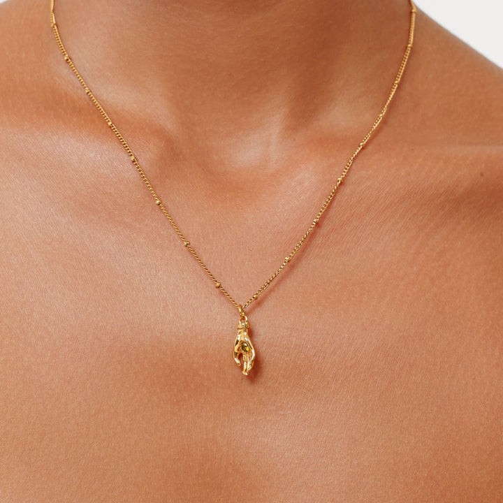 Goldfarbene Damenhalskette mit Schutz Hand Anhänger & grünem Zirkon. Eleganter Symbolschmuck aus Edelstahl.
