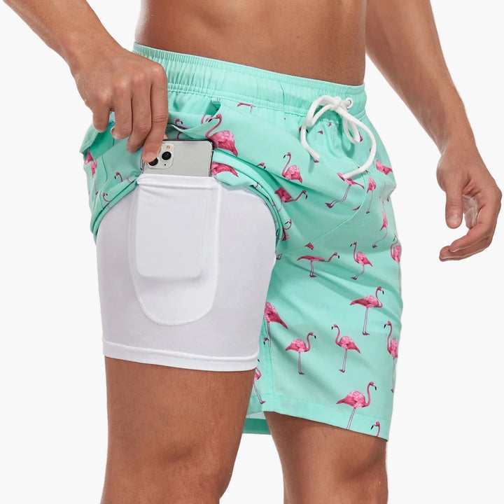 Sommerliche Herren Swimshorts im tropischen Look, schnelltrocknend und mit Kompressionsshorts für aktiven Strandurlaub.
