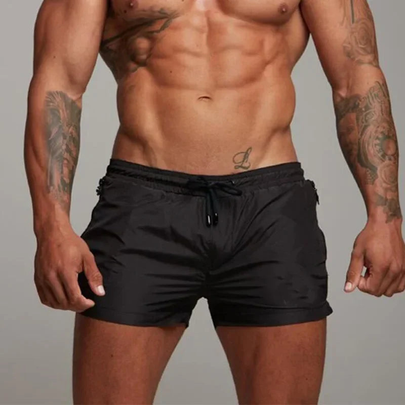 Herren Schwimmshorts mit Sonnenbrille & Handtuch am Strand. Moderne Badebekleidung für entspannte Sommertage.