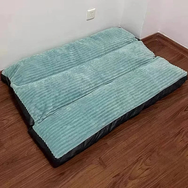 Ein glücklicher Hund ruht auf einem grauen, rutschfesten orthopädischen Tierbett.