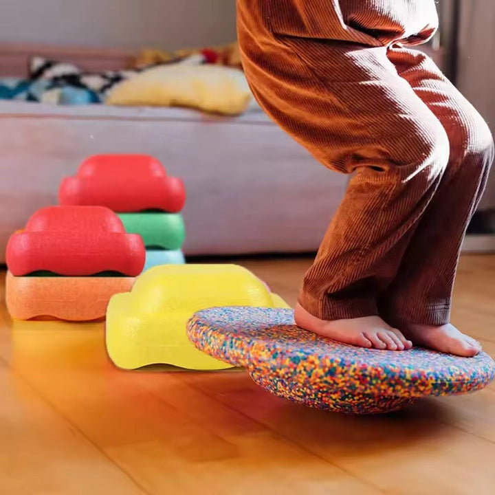 Kleinkind spielt mit bunten Balance-Stapelblöcken, die Koordination & Gleichgewicht indoor & outdoor fördern.