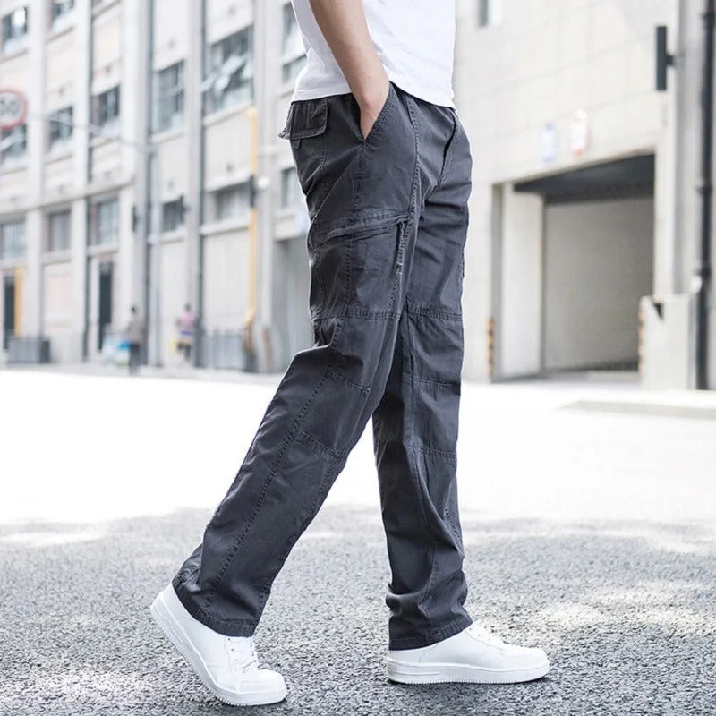 Modell trägt schwarze Herren Cargo-Hose mit lockerem Schnitt und bequemen Vier-Wege-Stretch. Für Freizeit und Reisen.