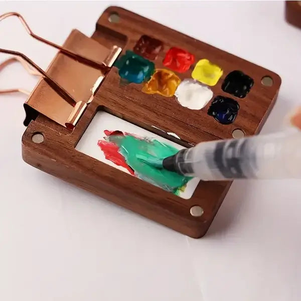Kind malt mit dem mobilen Aquarell-Malset (24 Farben, Pinsel), fördert Kreativität & Feingefühl.