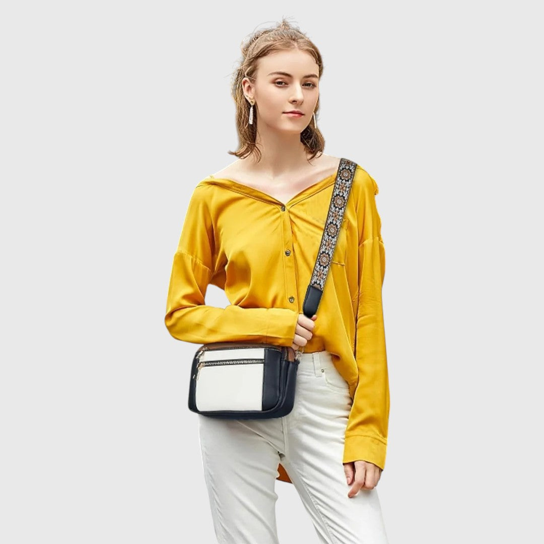 Detailaufnahme: Dekorativer Blumenriemen der modischen Damen Schultertasche aus Kunstleder. Farbenfrohes Accessoire.