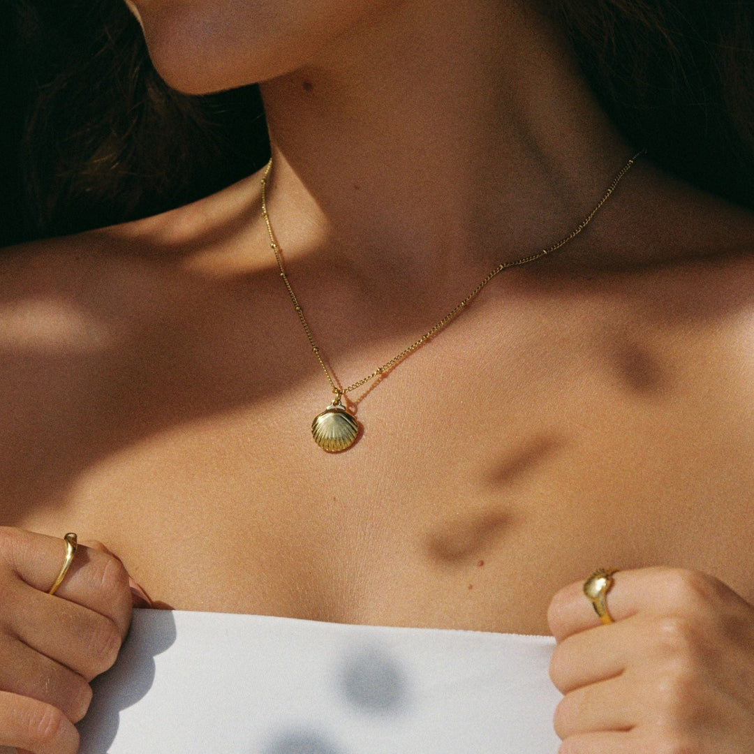 Stylische PVD-Goldkette für Frauen mit Muschel-Anhänger & runder Süßwasserperle, aus Edelstahl gefertigt.